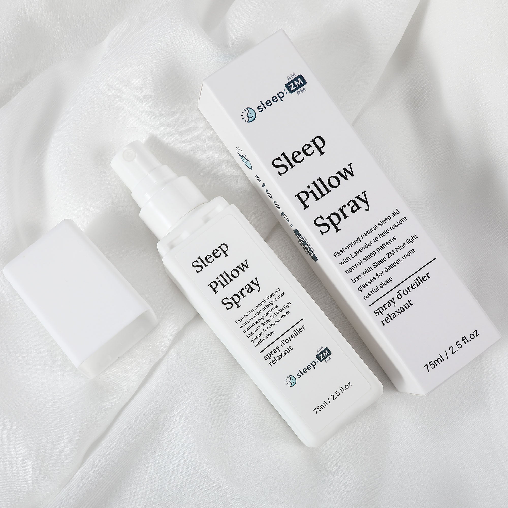 Sleep pillow spray bottle and packaging on a white fabric background