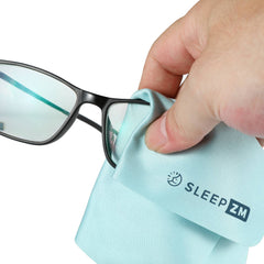 Hand cleaning a pair of glasses with a blue cloth labeled 'SleepZM' on a white background